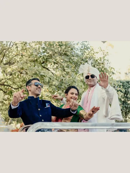 A fun and candid shot of the groom dancing in a car with his family during the Baraat.