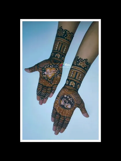 A view of the engagement mehendi, showing the heart with the date and the swan motif.