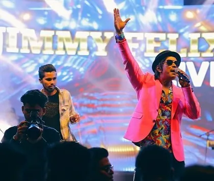 Reaching for the high notes during a live corporate concert. The pink jacket was just a bonus to the vibrant energy we brought to the stage that night.