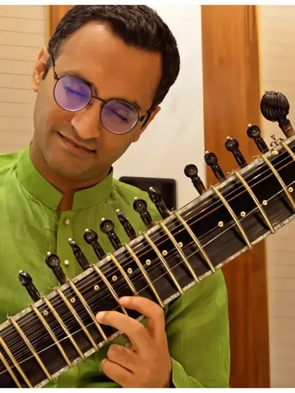 A close-up in a green kurta, playing Raag Darbari.