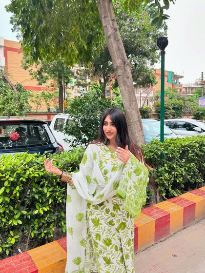 Another angle of the green and white suit, showing the flow of the dupatta. This highlights the complete three-piece set.