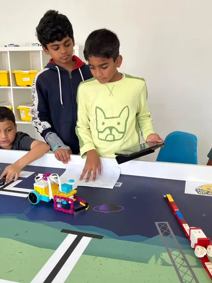 Teamwork is at the heart of competitive robotics. This photo captures a moment of intense collaboration as our students work together, combining their ideas to refine their robot's design and strategy for an upcoming World Robot Olympiad challenge.