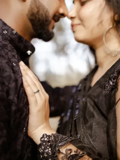 An intimate close-up focusing on the bride's hand on the groom's chest, showcasing the engagement ring and the couple's closeness.