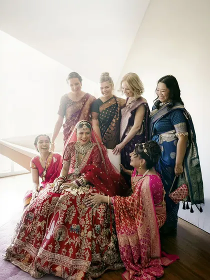 A happy moment between the bride and her bridesmaids, who are from different cultural backgrounds, all celebrating together.