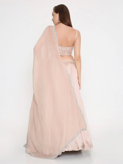 A back view of the blush peach lehenga, showing the simple, elegant dupatta and the perfect fit of the blouse. It's pretty without trying too hard.