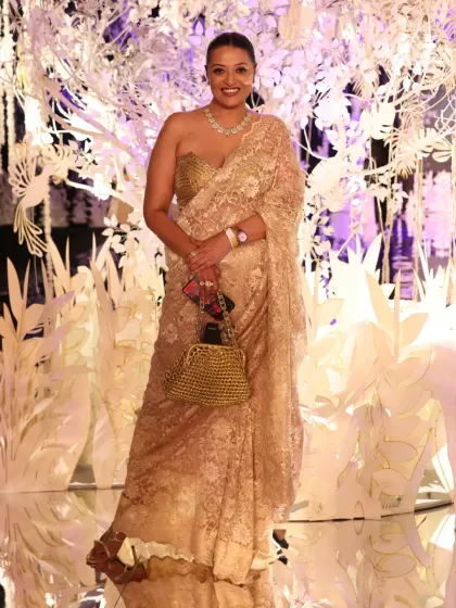 Attending the Suneet Varma show at India Couture Week in a golden lace saree. The look is completed with a modern bustier-style blouse and a statement necklace, creating an aura of classic Bollywood glamour perfect for a couture evening.