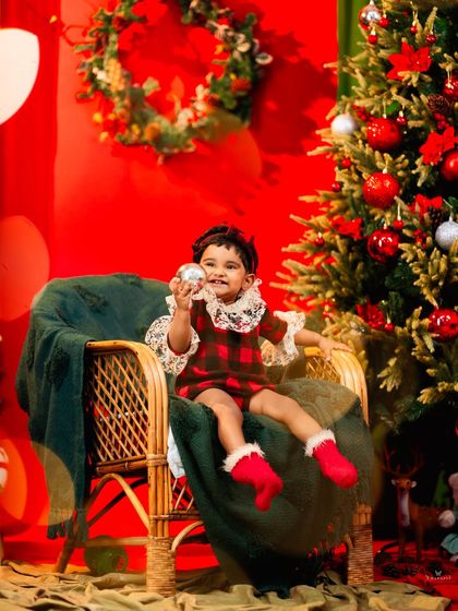 Playing with an ornament, this little girl is completely captivated by the magic of Christmas.