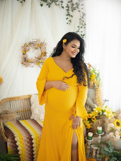 A bright and cheerful solo portrait in a sunshine yellow gown. The matching yellow flowers in the setup and her hair create a happy, sunny vibe.