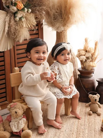 Two of a kind. This portrait of twin babies sitting together, surrounded by their teddy bear friends, is unbearably cute. The neutral color palette keeps the focus on their sweet faces.