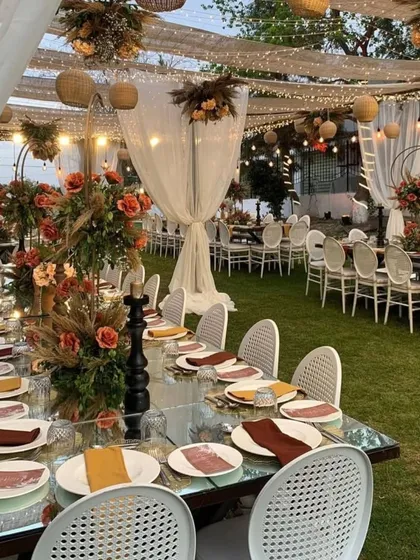 This elegant outdoor dining setup is perfect for an intimate celebration like a baby shower or anniversary. The mirrored tabletops reflect the sky and hanging decor, creating a magical atmosphere.