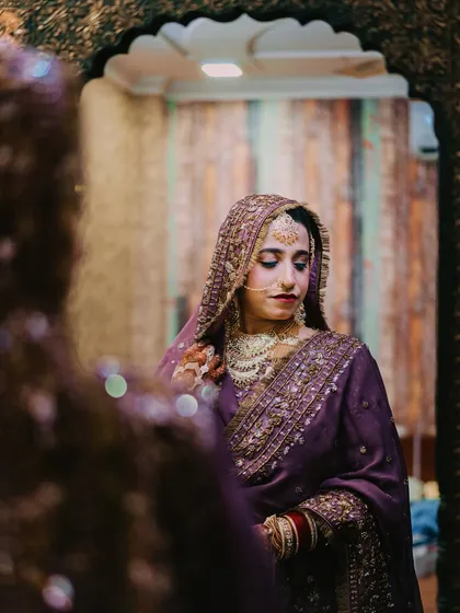 A quiet moment of reflection for the bride. This mirror shot adds depth and a story-like quality to the bridal portrait.