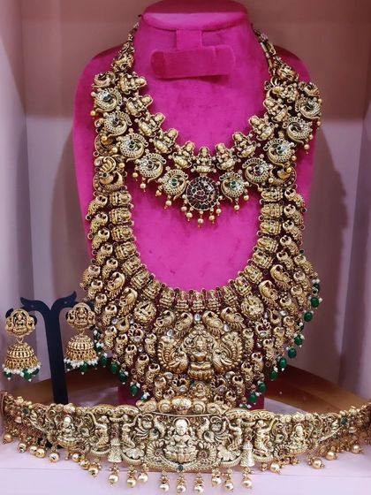 A magnificent bridal rental set, including a choker, a grand haram with a large deity pendant, and a matching vaddanam.