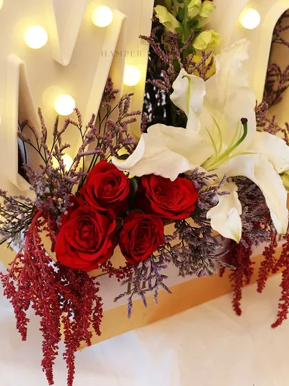 Another detail shot of the "MOM" hamper, this time focusing on the deep red roses and white lilies that add a touch of classic elegance.