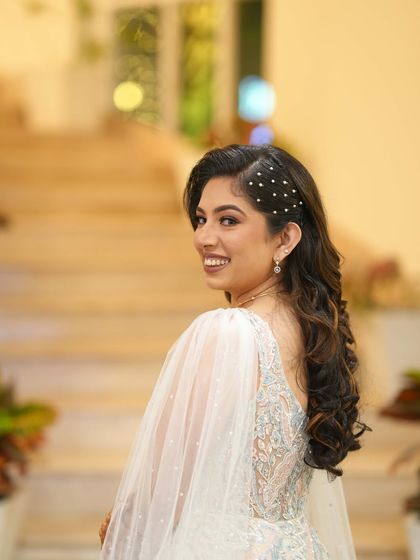A beautiful smile from my engagement bride. The side-swept hair with pearl details adds a touch of modern elegance to her classic party look.