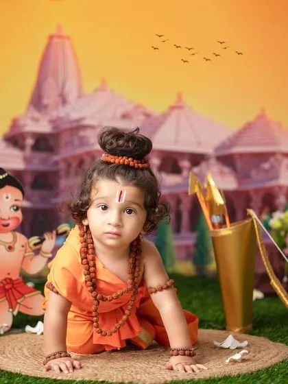 Jai Shri Ram! A little one dressed as Lord Rama crawls towards his bow and arrow, with Hanuman cheering him on.