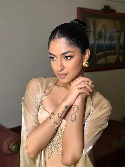 A side profile of the Latina glam, highlighting the sharp winged liner and the glowing skin. The sleek bun completes this modern and powerful look.