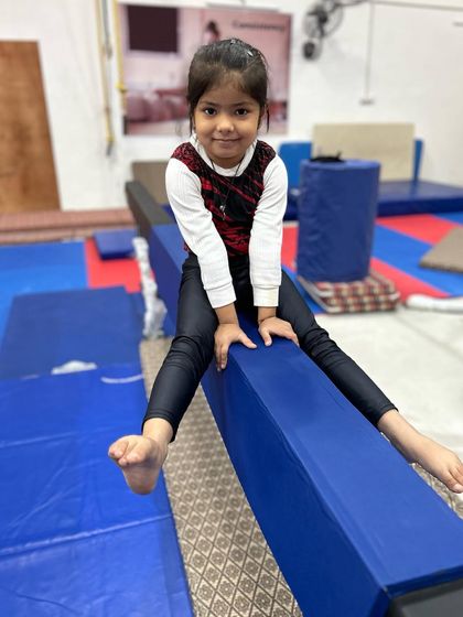 Even our tiniest gymnasts start learning on the beam. This little one is getting comfortable with the apparatus.