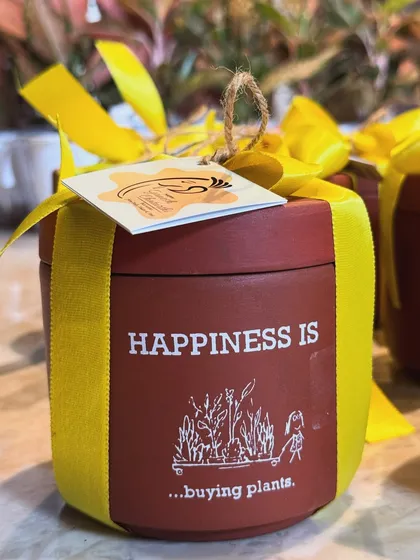 Happiness is buying plants. This custom-wrapped terracotta pot, ready for a festive order, says it all.