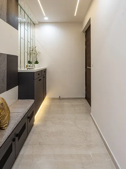 A view down the passage from the entryway. The clean lines, profile lighting, and neutral color palette create a calm and sophisticated transition into the rest of the home.