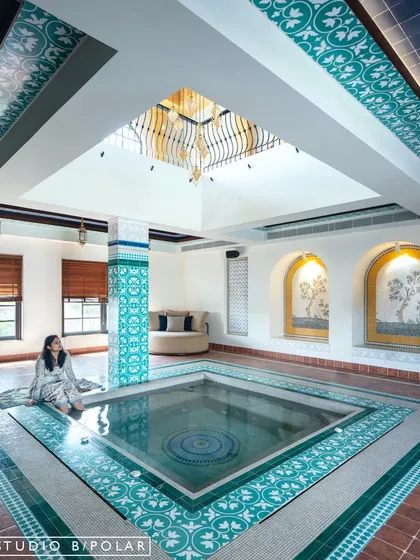 Inspired by the family's love for travel, we designed this serene, Moroccan-style indoor pool area for the Wanderlust Villa. The custom turquoise tiles, arched niches, and skylight work together to transport you to a tranquil riad, creating a personal oasis within the home.