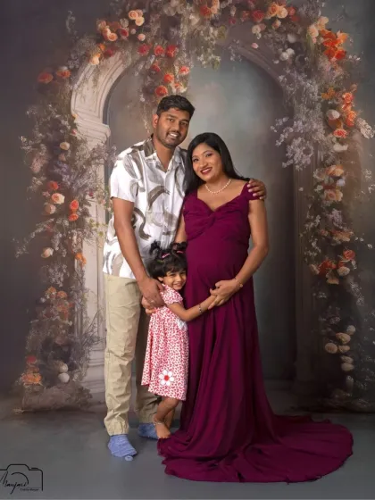 A beautiful family portrait. The older sibling joins in, creating a heartwarming image of a family excited to grow.