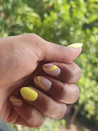 A playful and modern design using yellow gel polish. I combined solid yellow nails with accent nails featuring abstract lines and a touch of glitter over a neutral base.