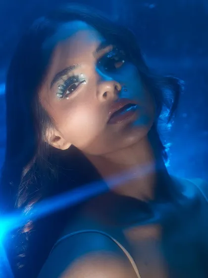 A dreamy, underwater-inspired look with blue lighting and sparkling eye makeup.