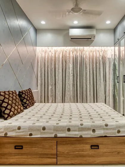 This bedroom design includes a wooden bed frame with built-in storage drawers, providing a practical solution for keeping the room tidy and organized.