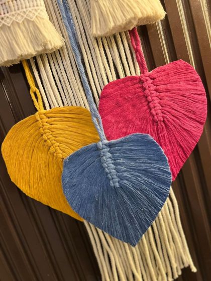 A close-up shot of the colorful, heart-shaped macrame leaves. I handcraft each leaf, and they can be added to any nameplate or wall hanging in your choice of colors.