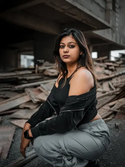 A confident, low-angle shot of the model squatting, her intense gaze directed at the camera, perfectly matching the edgy vibe of the location.