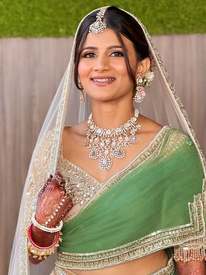 A happy bride, ready for her daytime wedding. The makeup is minimal and fresh, allowing her natural beauty to shine through in her gorgeous green saree.