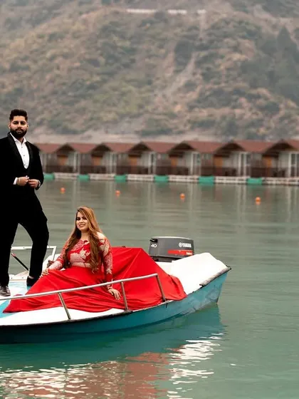 A beautiful pre-wedding portrait on a boat in Tehri Lake. The serene water and the backdrop of floating cottages create a unique and picturesque setting for a romantic photoshoot.