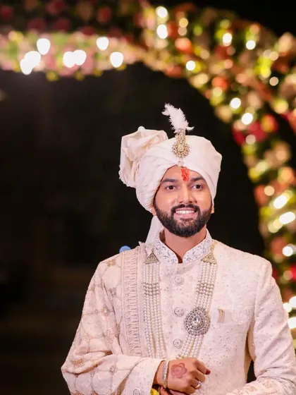A classic groom portrait. He stands under a beautifully lit archway, his sherwani and smile radiating warmth and happiness.