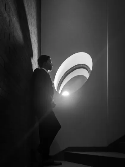A creative use of architectural light and shadow to create a dramatic, solitary portrait of the groom. This black and white shot has a moody, film noir quality.