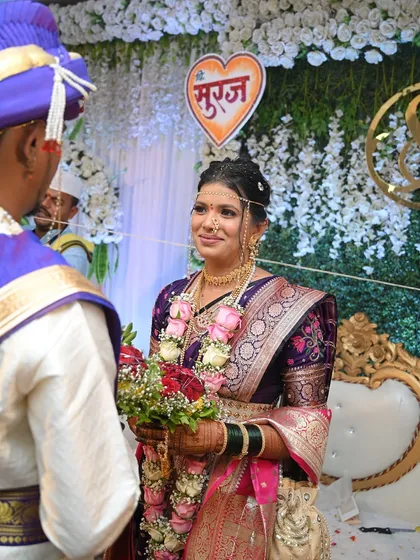 A beautiful moment during the Varmala ceremony. The bride's makeup in her purple Paithani is elegant and photographs beautifully.