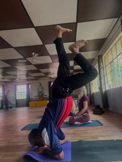 Moving into an advanced headstand variation requires focus and core strength. The journey is just as important as the final pose.
