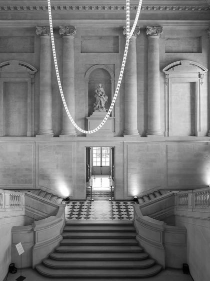The grand staircase at the Palace of Versailles. The symmetry and classical architecture are highlighted in this monochrome photograph.