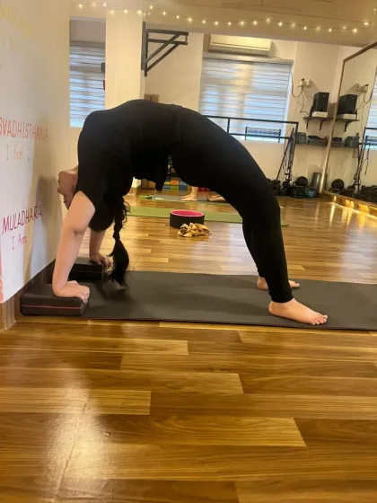 Using the wall and blocks for support in Urdhva Dhanurasana (Wheel Pose) helps build strength and confidence in backbends.
