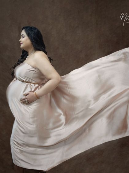 A classic profile portrait with a flowing satin gown. This pose emphasizes the beautiful silhouette of pregnancy in a simple and elegant way.