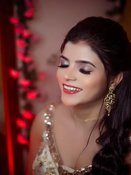 A soft and beautiful portrait with her eyes closed in a moment of happiness. The warm, colored lighting adds to the romantic and dreamy mood.