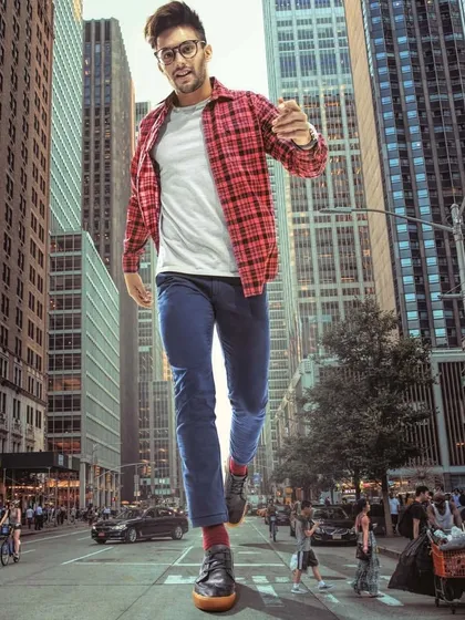 This surrealist campaign for Citrus places a casually styled giant in the heart of New York City. The relaxed look, featuring a plaid shirt over a tee and jeans, creates a striking contrast with the massive scale.