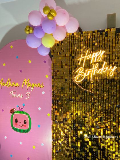 A dual backdrop featuring a pink Cocomelon panel and a gold shimmer wall. This combination adds a touch of glamour to the playful kids' theme.