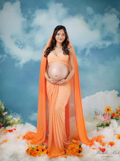 A full-length portrait in the dreamy cloud setup, showing the mother-to-be as a true goddess standing among the heavens.