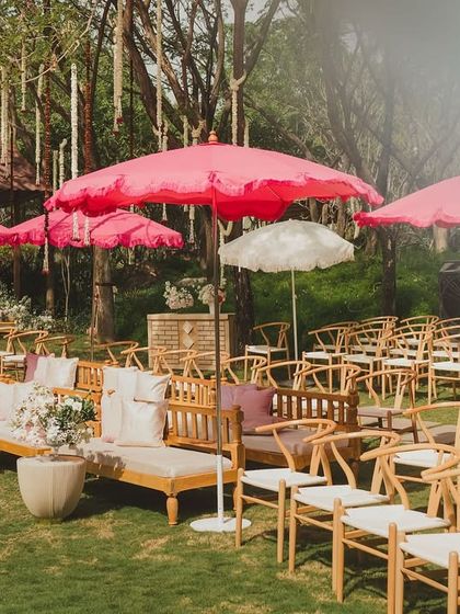 Bright pink umbrellas provide shade and a pop of color over the guest seating area on the lawn.