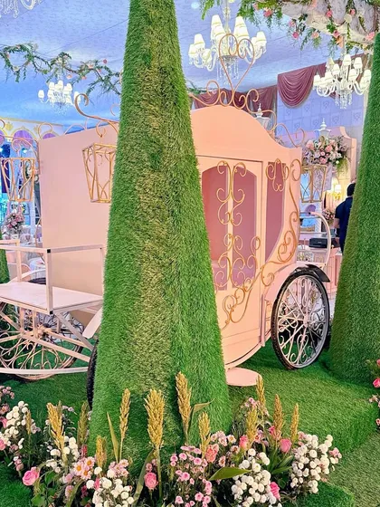 Another angle of the princess carriage, showing the intricate gold details and surrounding floral arrangements.