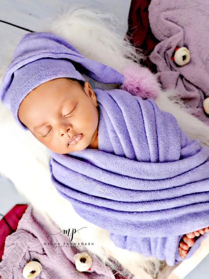 A full-body shot of the baby in his purple wrap.