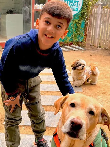 A young boy enjoying our outdoor area with our resident dogs, Bunny and Tofu. It's a great way for kids to learn how to interact gently with animals.