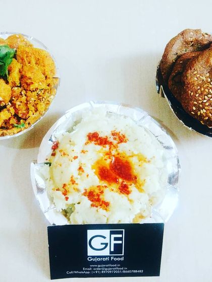 A special snack platter featuring three favorites: soft rice flour Khichu, savory Muthiya, and crispy Bajri Vada. This is a great way to sample different Gujarati snacks.