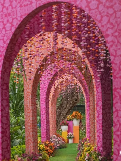 Your guests' first impression matters. This stunning floral tunnel, with its repeating pink arches, creates a spectacular welcome and an unforgettable photo opportunity, setting the tone for a magical event.