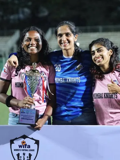 Three of our senior players holding the WIFA championship trophy, representing the leadership and experience within our squad.